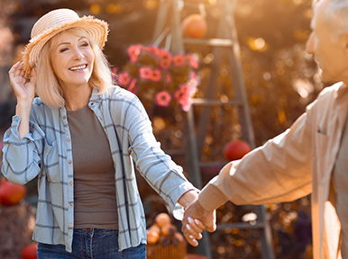 Enhancing Your Daily Confidence Older couple holding hands outdoors, representing lasting oral health and quality dental care for seniors