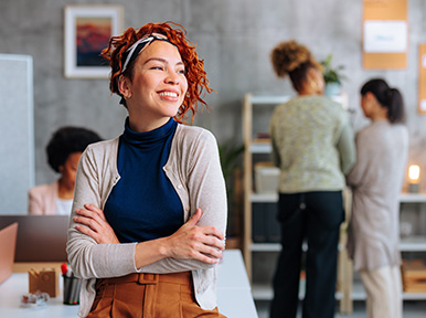 Woman smiling in modern office, representing welcoming dental team and positive patient experience