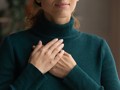 Increased cardiovascular health Person with hands on chest, representing compassionate dental care and patient comfort focus