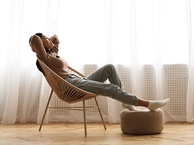 Maximizing Your Comfort CEREC Woman relaxing in chair at home, representing comfortable, stress-free dental care experience